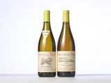 two bottles of wine sitting on top of a table next to each other