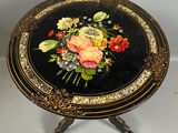 une table noire ornée d'un motif floral