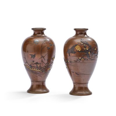 deux vases marron ornés de motifs, placés l'un à côté de l'autre