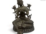 une statue en bronze d'une femme assise sur un rocher