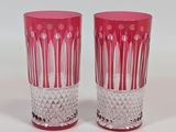 pair of pink glass vases on a white surface with a white background