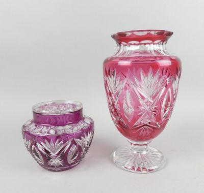 des vases en verre violet et rose posés côte à côte sur une surface blanche