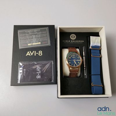 a box with a watch and a pen in it