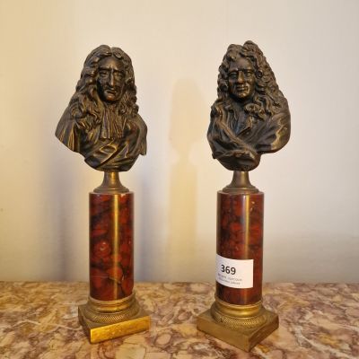 une paire de bustes en bronze représentant un homme et une femme, posés sur des socles en marbre