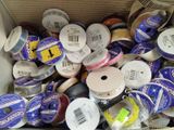 de nombreuses bobines de différentes couleurs et tailles dans une boîte