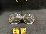a close up of a pair of glasses and a pair of earrings