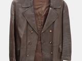 brown leather jacket hanging on a hanger on a white wall
