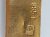 a close up of a gold bar on a white surface