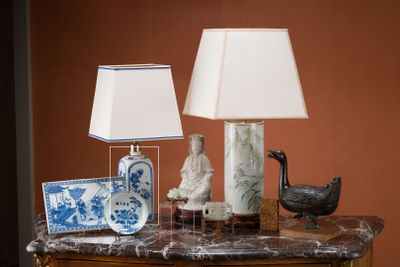 une table sur laquelle se trouvent une lampe, un vase et un oiseau