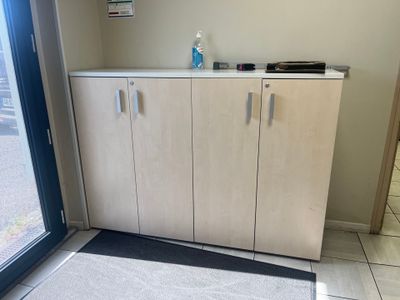 une armoire avec une porte et un paillasson posé au sol