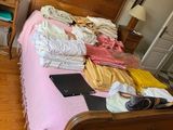 a bed that has a lot of clothes on top of it