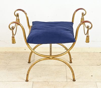a gold bench with a blue cushion on top of it