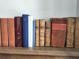many books that are on a shelf in a room
