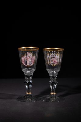 two wine glasses sitting on top of a table next to each other