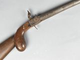 un gros plan d'un fusil à crosse en bois posé sur une surface blanche