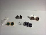 trois paires de boucles d'oreilles et une paire de boucles d'oreilles sont posées sur une table