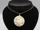 un collier plaqué or avec un pendentif représentant l'arbre de vie, présenté sur un mannequin noir