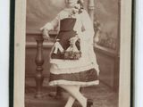 une vieille photo d'une femme en robe et avec un chapeau