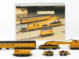 a toy train set with a yellow train car and other toy trains
