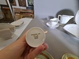a person holding a cup and saucer with a quote on it