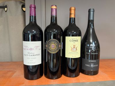 quatre bouteilles de vin sont alignées sur une table