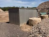 a small building in the middle of a gravel field