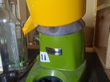 a green and yellow juicer sitting on a counter