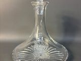 a clear glass bottle with a flower design on it