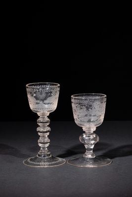 two clear glass goblets sitting on top of a black table