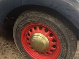 a black truck with a red rim parked in a garage