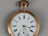 une montre de poche en or avec des chiffres romains