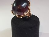an image of a ring with a red stone on top of a black box