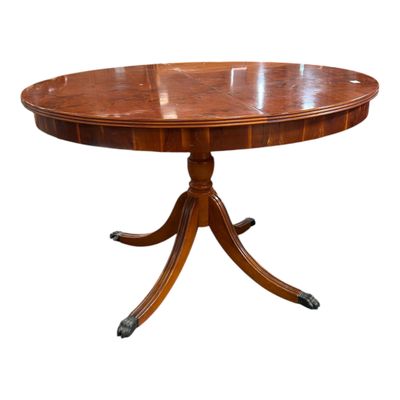une table à manger ronde avec un plateau en bois et quatre pieds