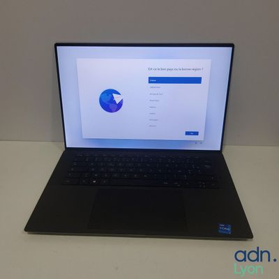 un ordinateur portable ouvert posé sur une table blanche