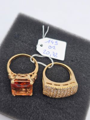 paire de boucles d'oreilles dorées ornées d'une pierre orange et de cristaux