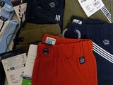 several pairs of men ' s pants are laid out on a bed