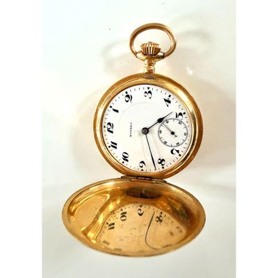 une montre de poche en or posée sur une table