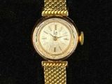 a close up of a gold watch on a black surface