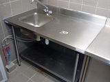a stainless steel sink in the corner of a kitchen