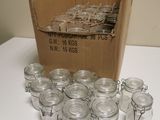 many glass jars sitting on a table with a cardboard box in the background