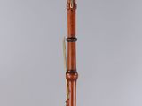 a wooden bassoon on a stand with a black base