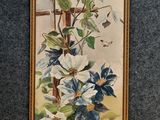 Un tableau représentant une fleur bleue et blanche est accroché au mur.