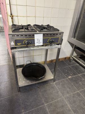 une photo d'une cuisine avec deux cuisinières et une casserole posée sur un support