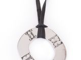 collier en métal argenté orné d'un ruban noir sur fond blanc