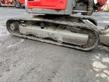 an image of a red and gray excavator in a parking lot