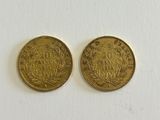 two gold coins on a white surface