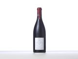 a bottle of red wine sitting on top of a white table
