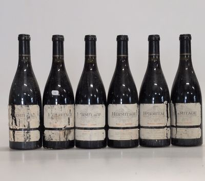 six bottles of wine are lined up in a row on a table