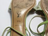 une paire de chaussures vertes à lacets posée sur une surface blanche