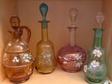 de nombreux vases en verre de différentes couleurs posés sur une étagère